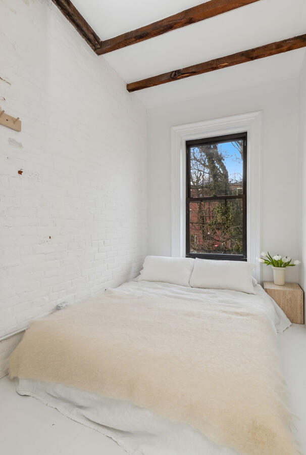 Guest bedroom with window looking out into the garden backyard