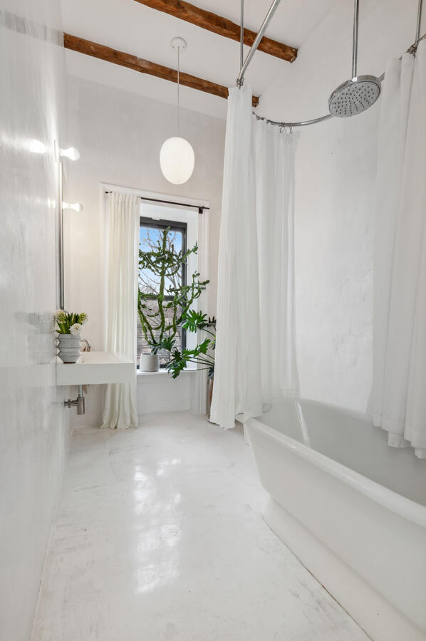 The bathroom is like a contemporary spa with heated epoxy floors, Venetian Plaster walls, a huge free-floating cast iron tub and contemporary fixtures.