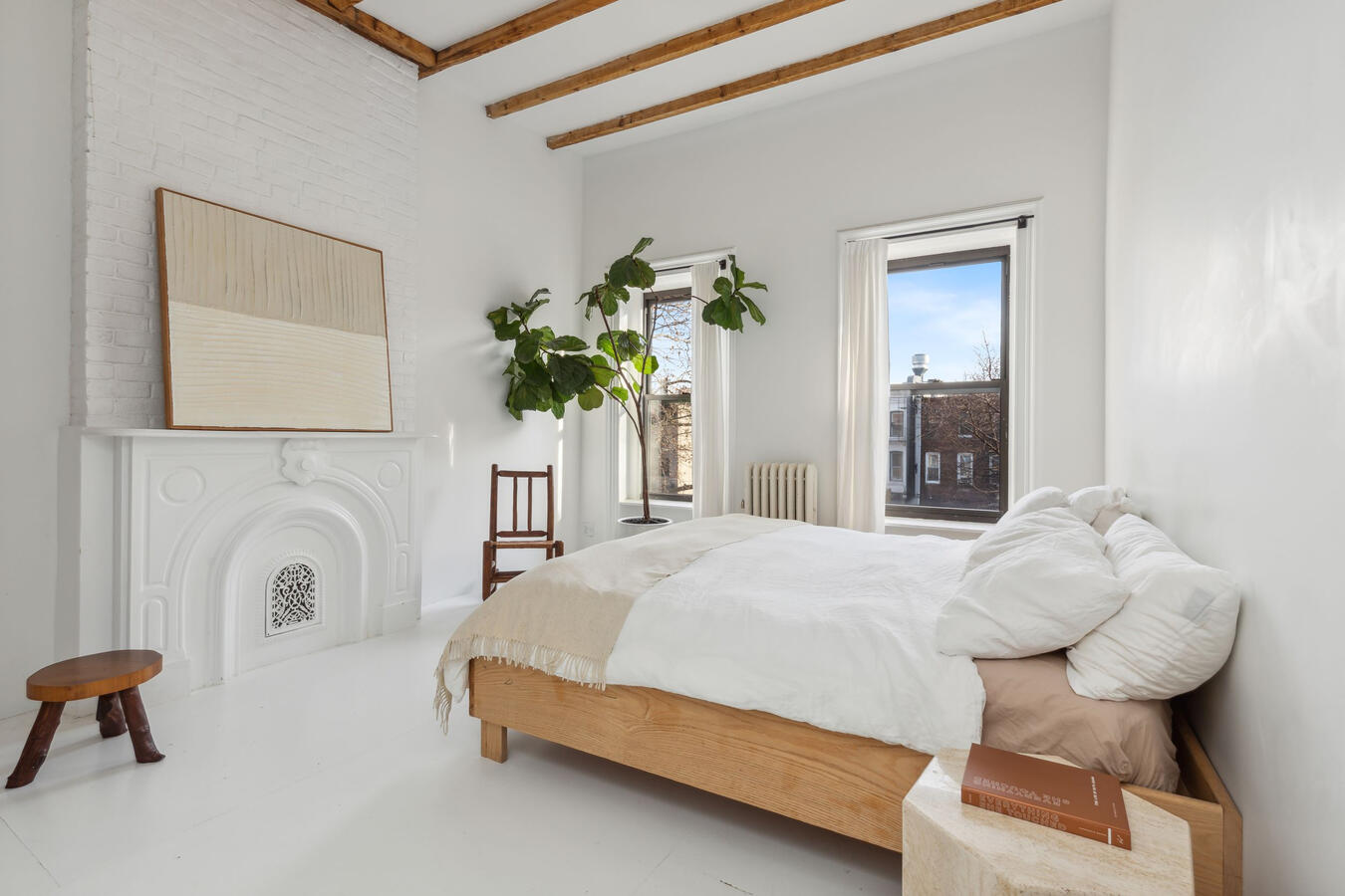 The primary suite, an airy oasis with a large walk-in closet, is the perfect spot for rest and relaxation with big south-facing windows framed by linen curtains.